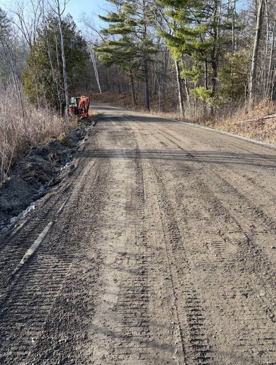 Freshly graded gravel road through forested property in Eastern Ontario